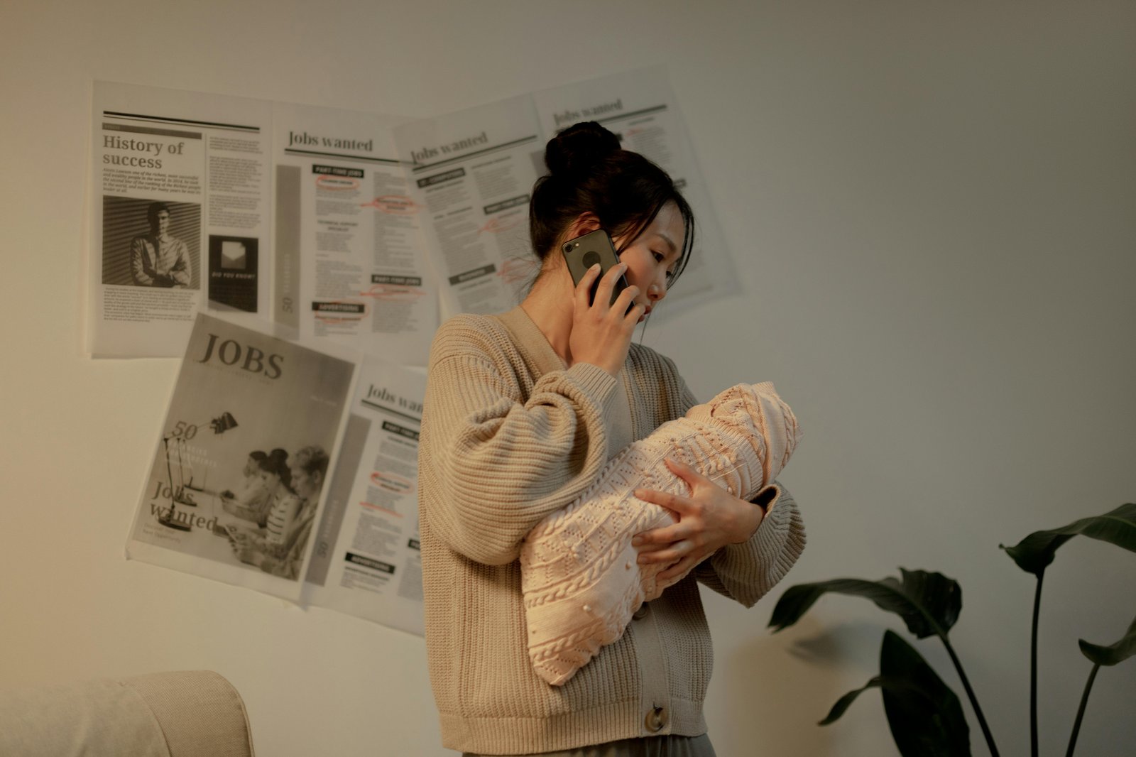career woman postpartum recovery — new mother holding newborn